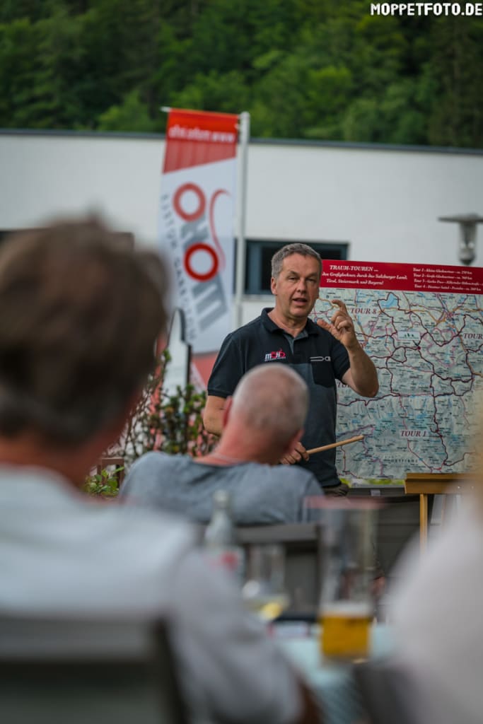 Mann erklärt eine Karte vor einer kleinen Gruppe im Freien