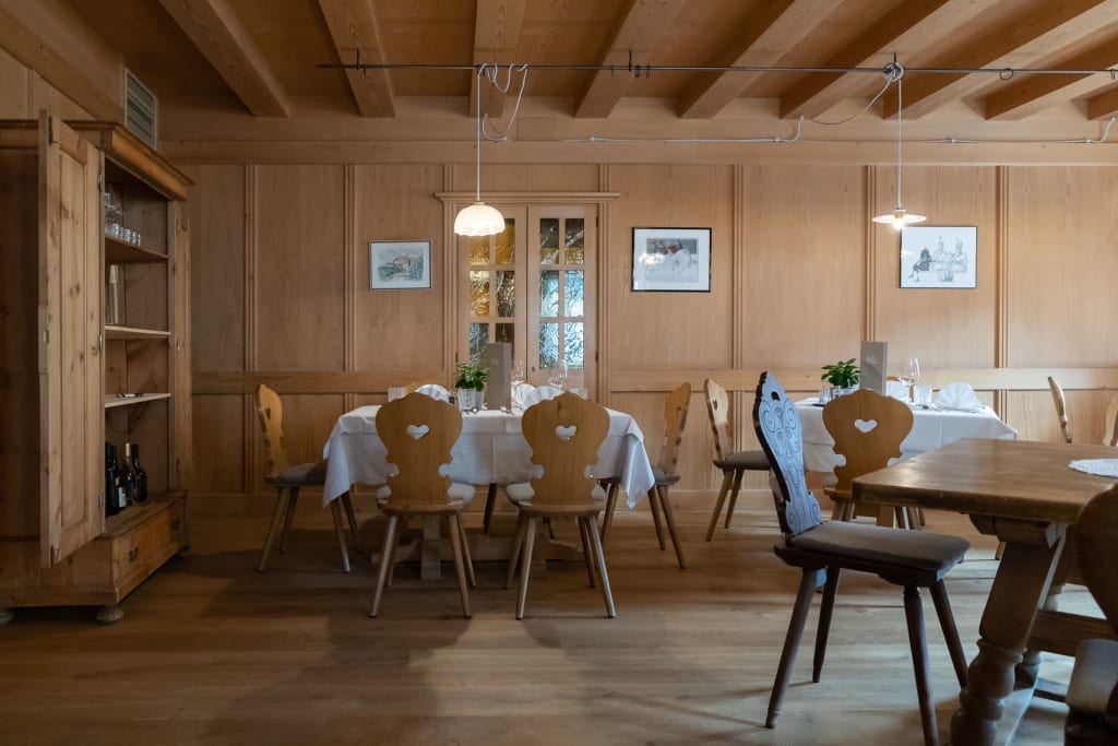 Traditionelles Esszimmer mit Holzmöbeln und Tisch mit weißer Tischdecke