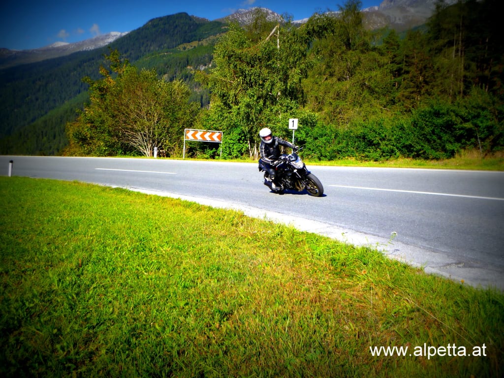 Motorrijder op een bochtige bergweg op een zonnige dag