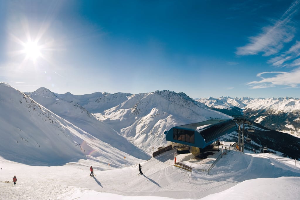 Zonnige skidag met kabelbaanstation en besneeuwde bergen
