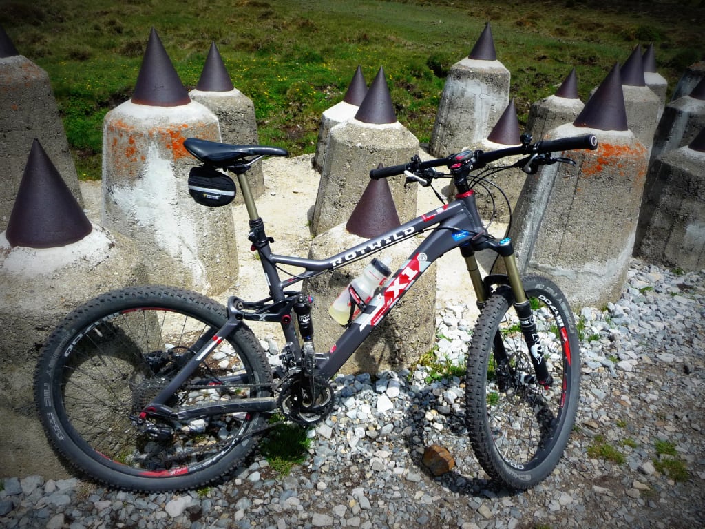 Mountainbike bij betonnen pilaren met metalen punten op grind