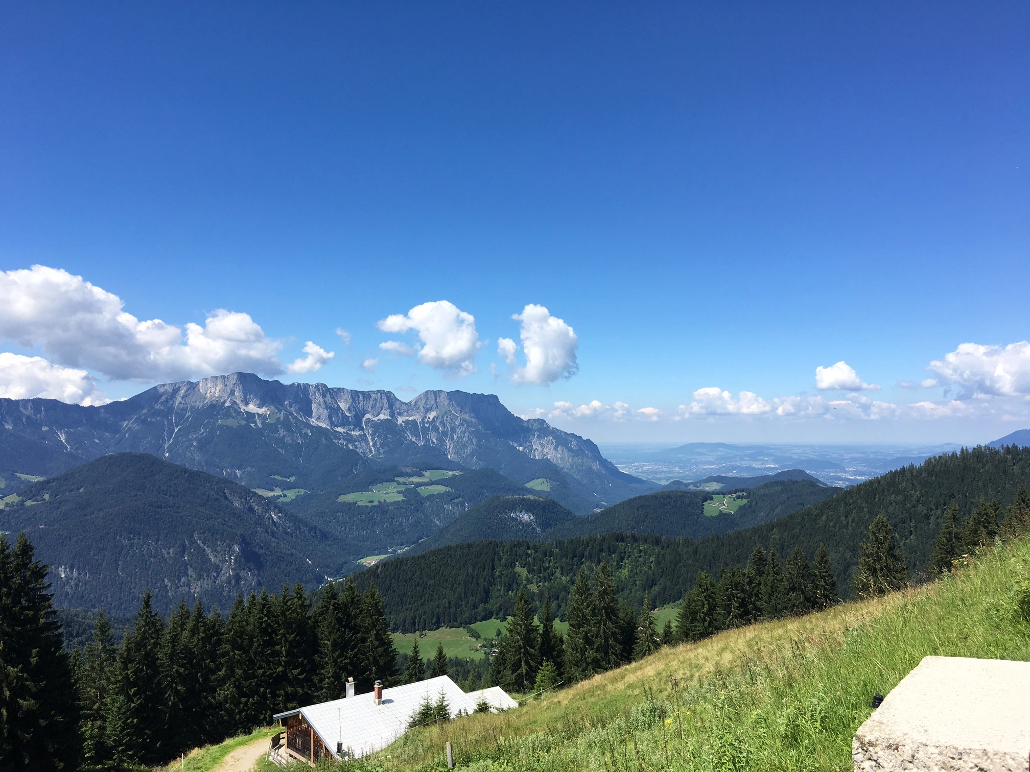 View of mountains, forest, and valley under a clear blue sky